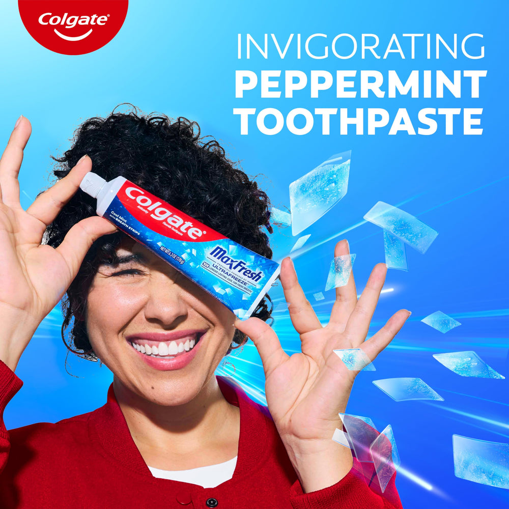 Person brushing teeth with Colgate MaxFresh in a bathroom setting.