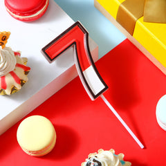 Conelist 7 numeral topper adds warm glow to cakes at celebrations.