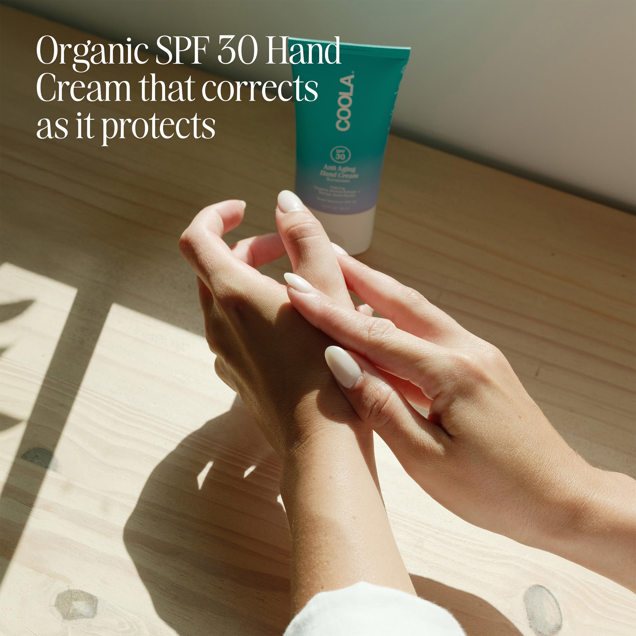 COOLA hand cream in use applying SPF 30 on skin