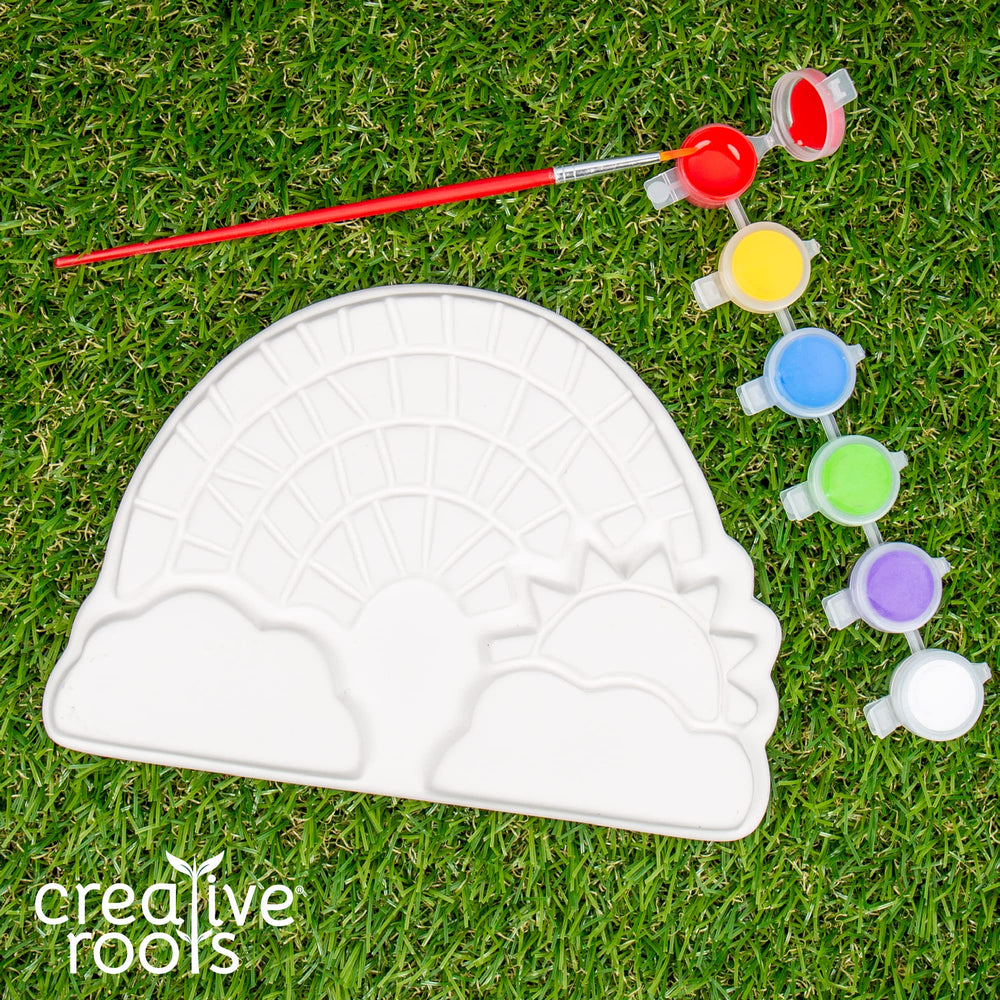 Creative Roots paintbrush and acrylic paints close-up for DIY rainbow patterns.