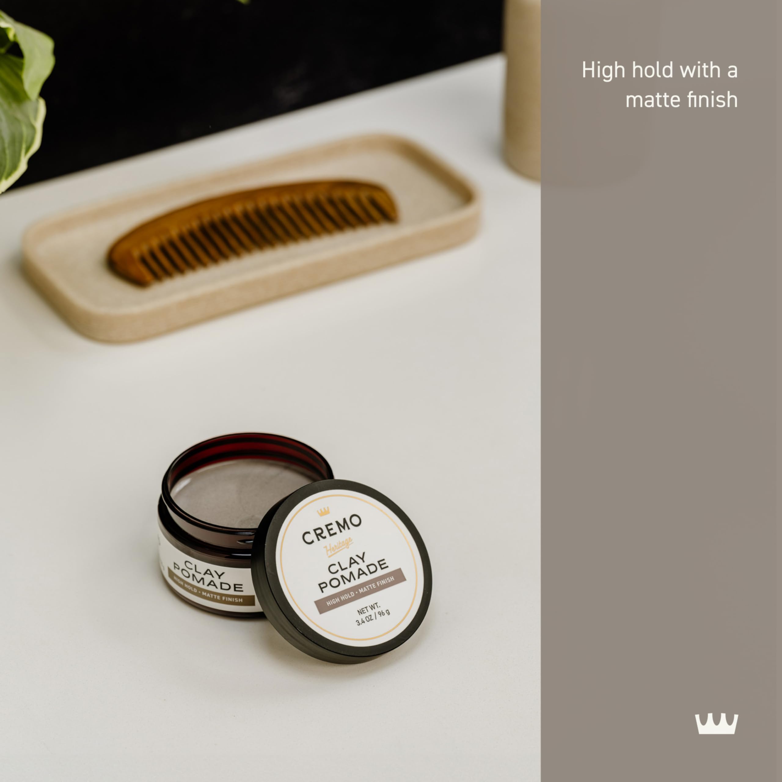 Cremo Hair Styling Clay in hand, ready for damp-hair application to boost volume.