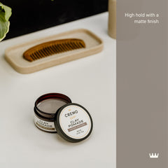 Cremo Hair Styling Clay in hand, ready for damp-hair application to boost volume.