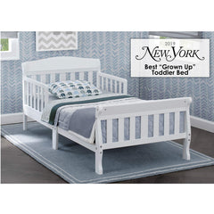Delta Children Canton Toddler Bed White side view shows sturdy wood frame.