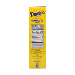 Domino Cane Sugar scooped on spoon showcasing crystalline texture