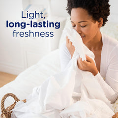 Downy Light Laundry Scent Beads being poured into washer for long-lasting aroma.