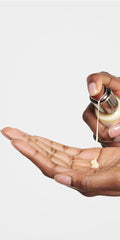 Hands applying Revitalizing Day Lotion during a simple morning routine.