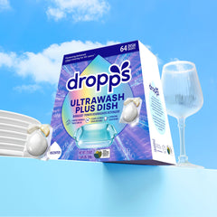 Dropps UltraWash Plus pods beside glassware showing streak-free shine.