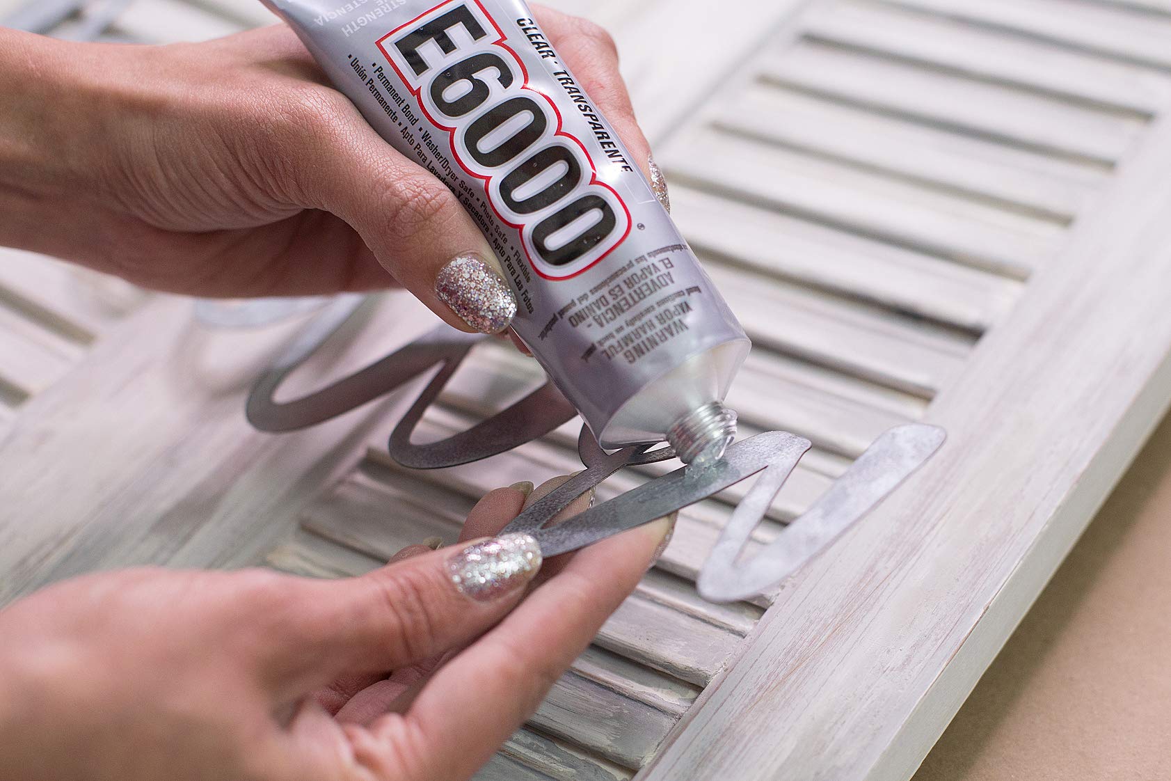 E6000 Craft Adhesive spread on wood demonstrates strong adhesion for crafts.
