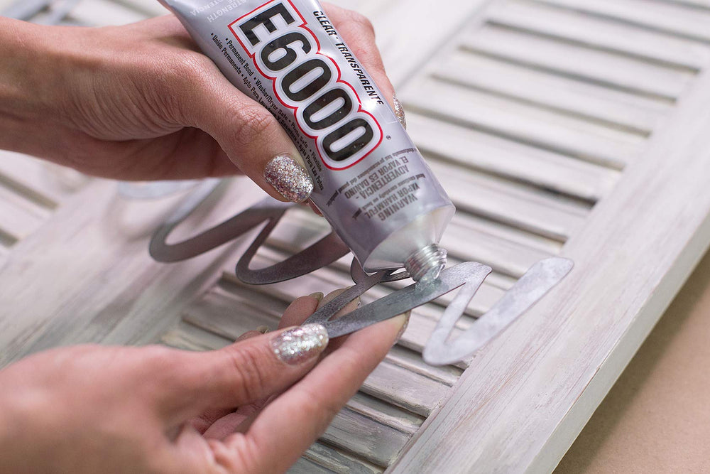 E6000 Craft Adhesive spread on wood demonstrates strong adhesion for crafts.