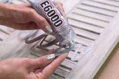 E6000 Craft Adhesive spread on wood demonstrates strong adhesion for crafts.