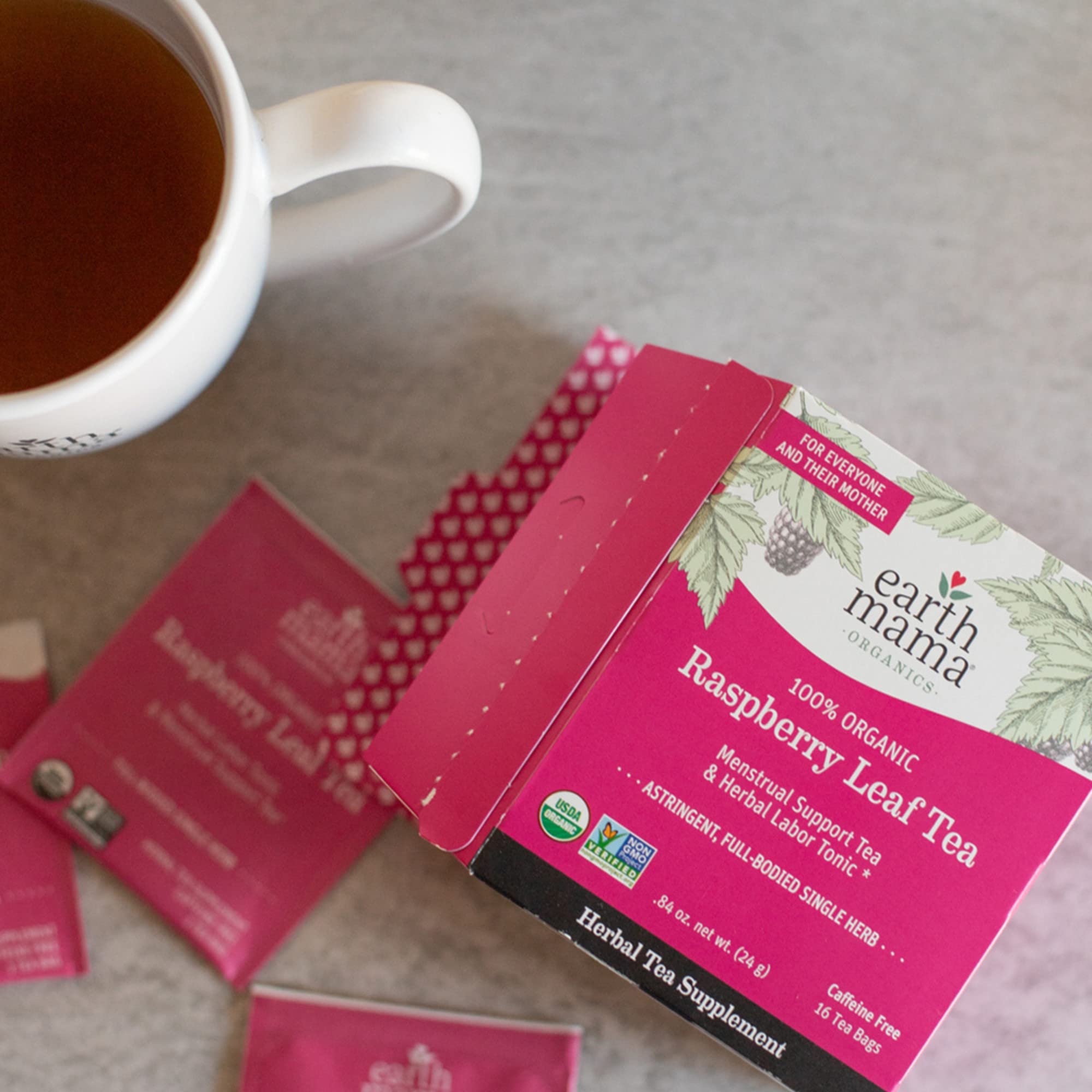 Earth Mama Organic Red Raspberry Leaf Tea box beside cozy setup, family friendly and non GMO