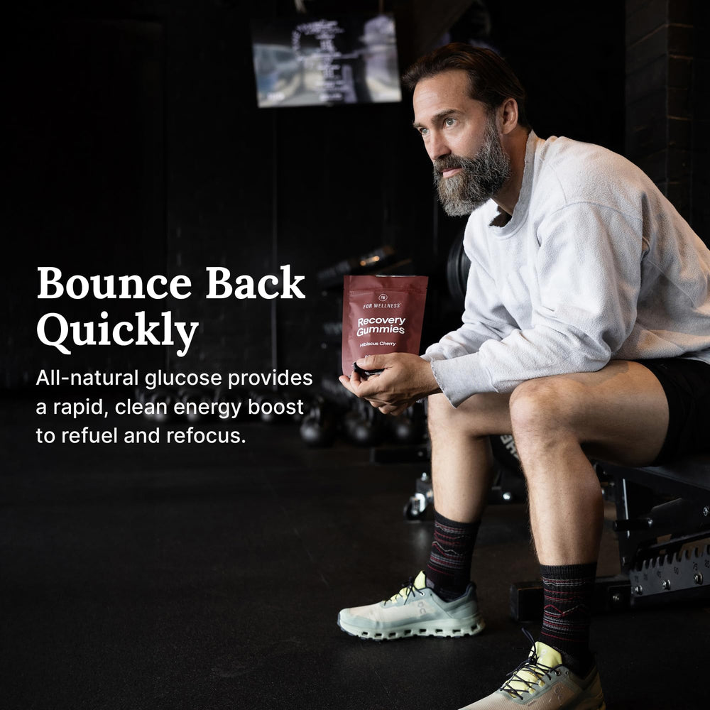For Wellness Recovery Gummies Restore gummies shown with a glass of water.