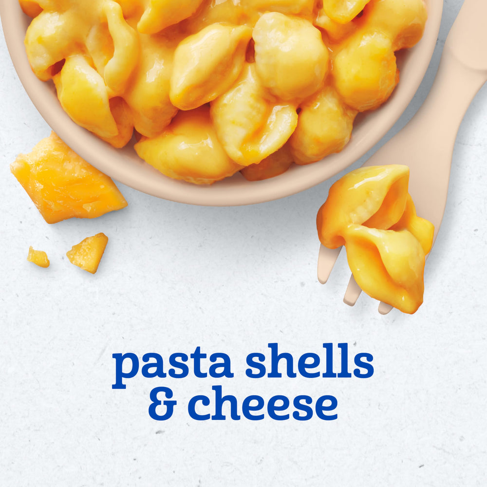 Small hands with Gerber pasta, baby-led feeding moment.