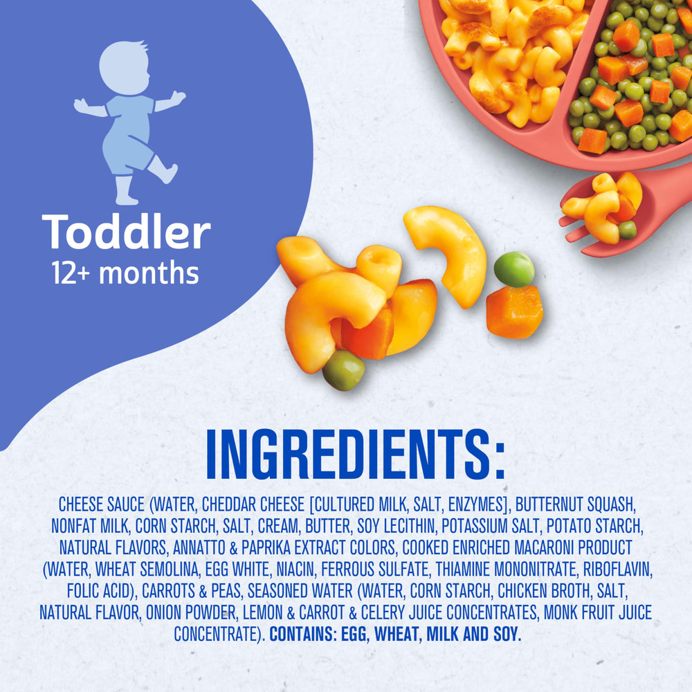 Toddler standing and reaching for plated meal during mealtime