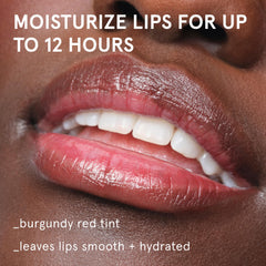 Glossier Balm Dotcom 15ml tube closeup showing burgundy tint for lip conditioning.