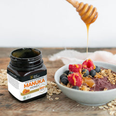 Good Natured Manuka Honey spoon dipping into jar, highlighting thick, syrupy texture