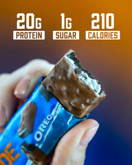 Grenade OREO milk chocolate bar unwrapped on table showcases creamy texture for post-workout treat