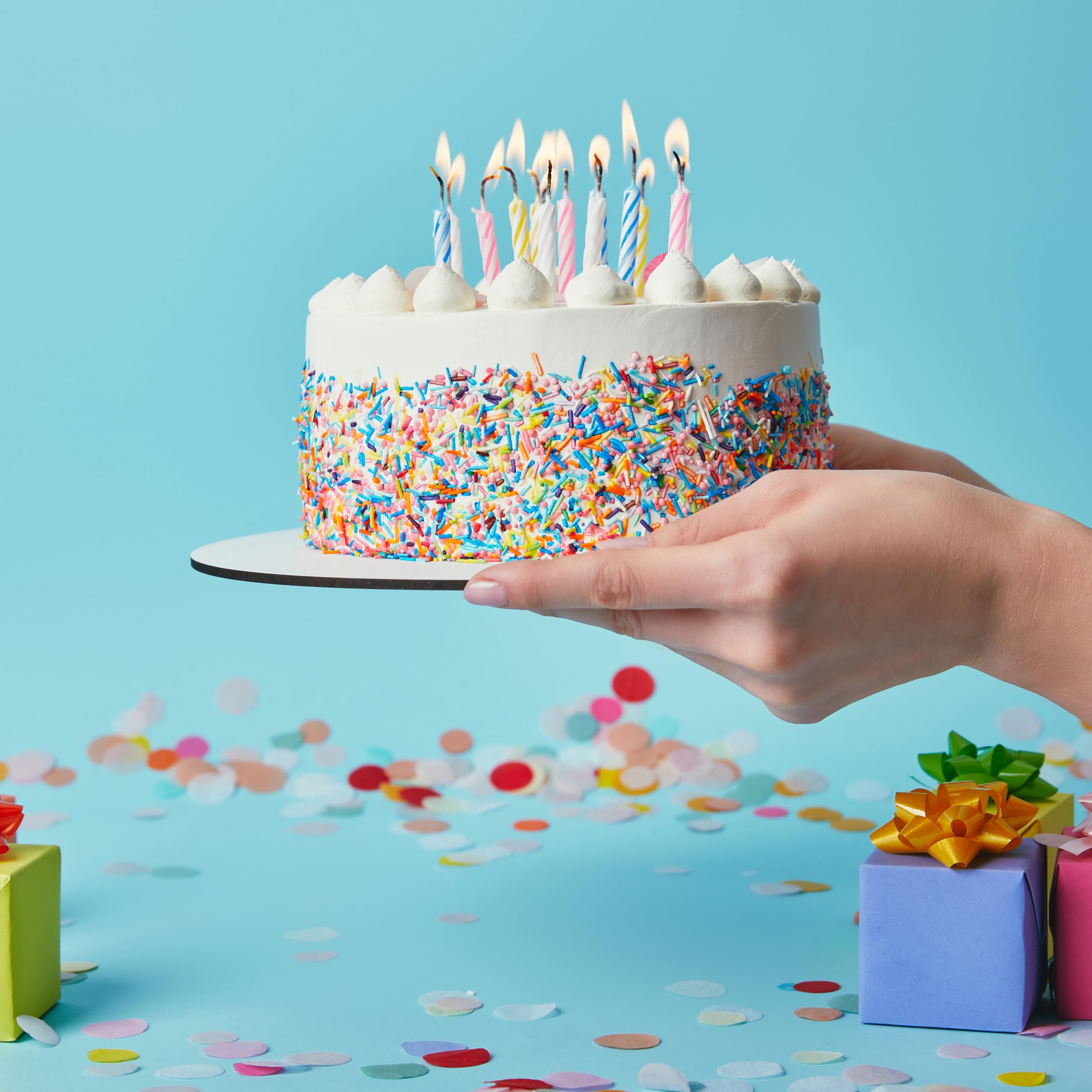 Hampton Distribution colorful spiral candles on cupcakes for playful dessert decor.
