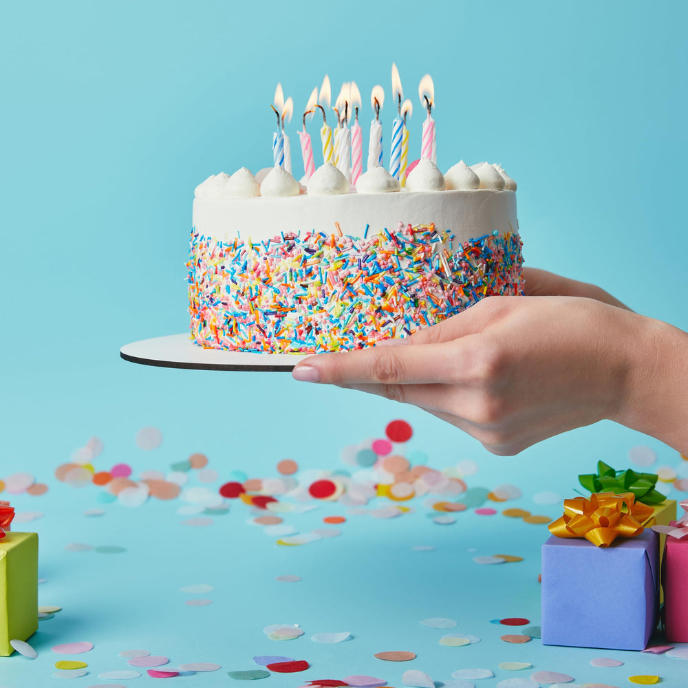 Hampton Distribution colorful spiral candles on cupcakes for playful dessert decor.