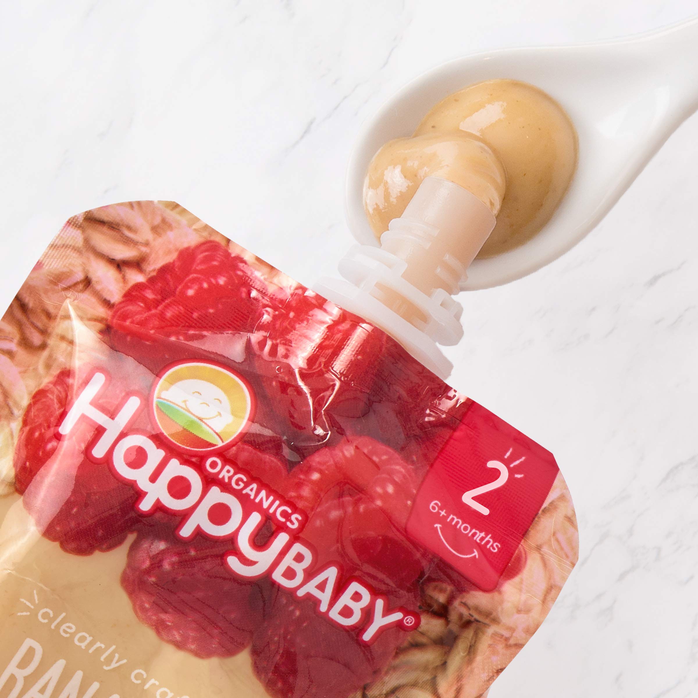 Happy Baby Organics pouch beside spoon, ideal for baby-led feeding practice
