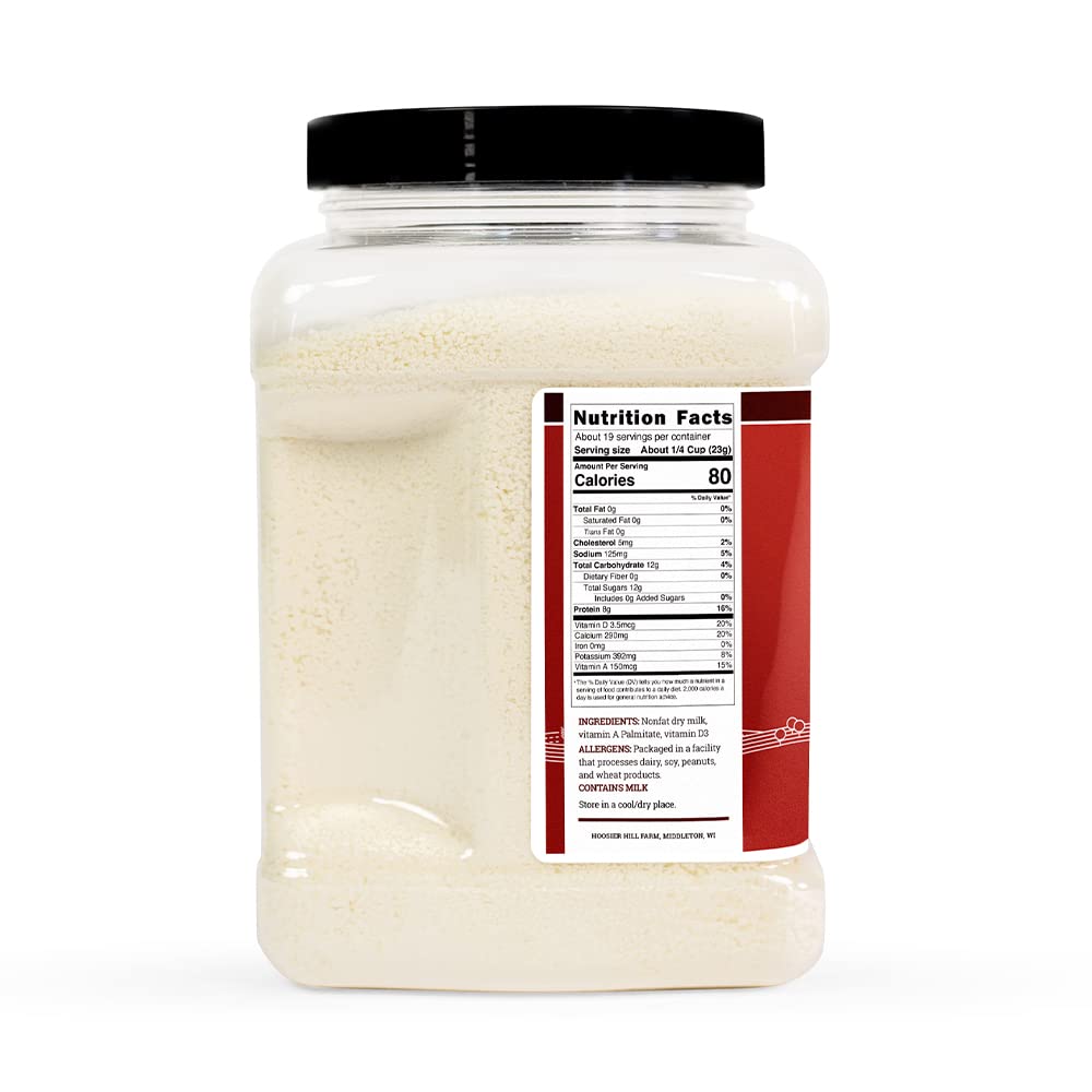 Pouring Hoosier Hill Farm instant nonfat milk powder into a glass for a creamy drink.