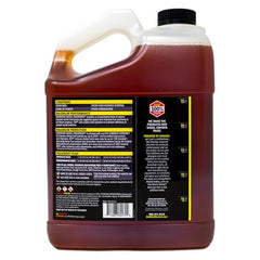 Hot Shot's Secret EDT gallon container beside a diesel pump for dosing at fill-up.