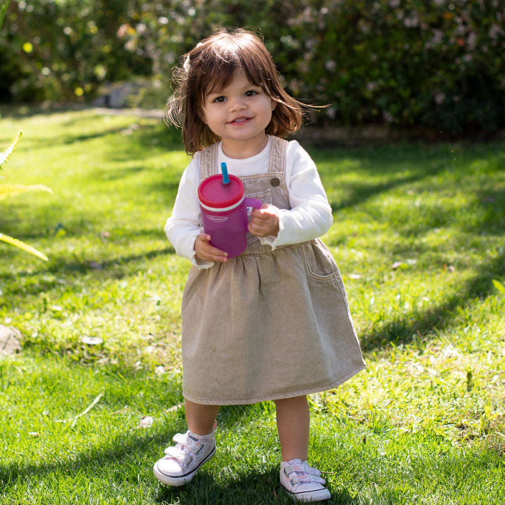 Infantino My 1st Tumbler in use beside a stroller shows universal cup holder compatibility.