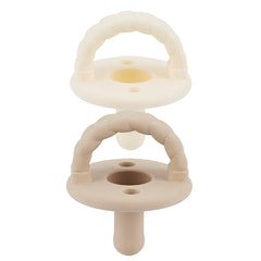 Itzy Ritzy silicone pacifier set in Buttercream and Toast for soothing comfort.