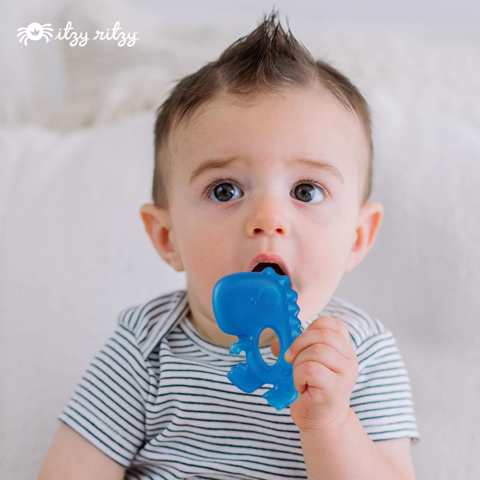 Itzy Ritzy dinosaur teether with easy grab design sits securely in tiny hands.