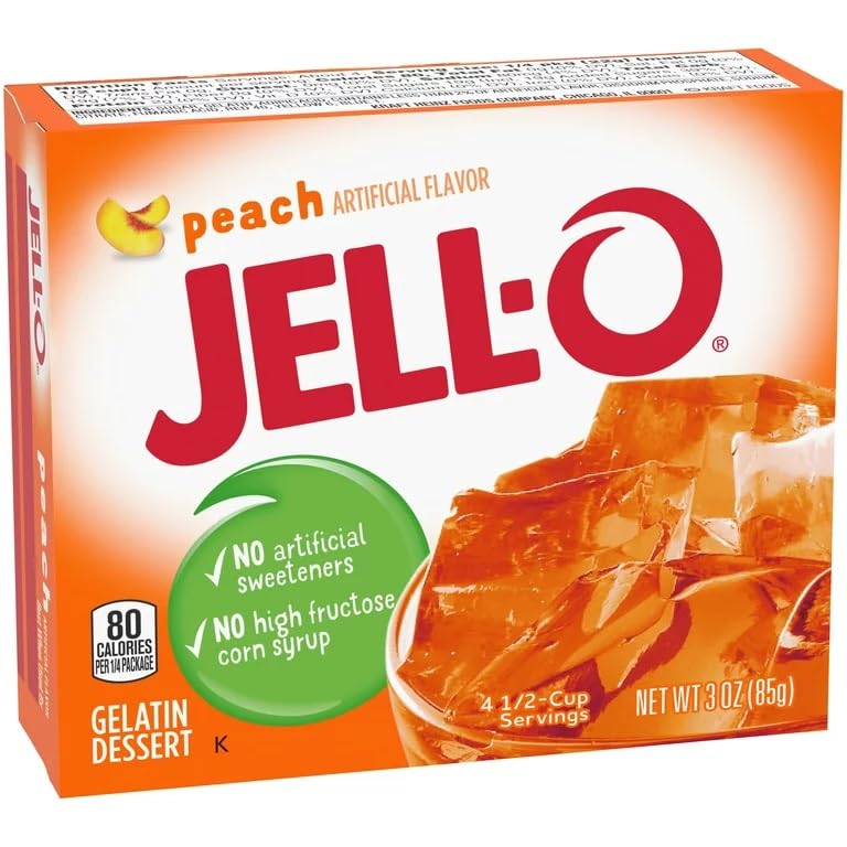 Stirring Jell-O Peach Gelatin with a spoon for smooth mixing.