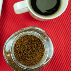 Kaffree Roma being stirred into a cup for quick brew.