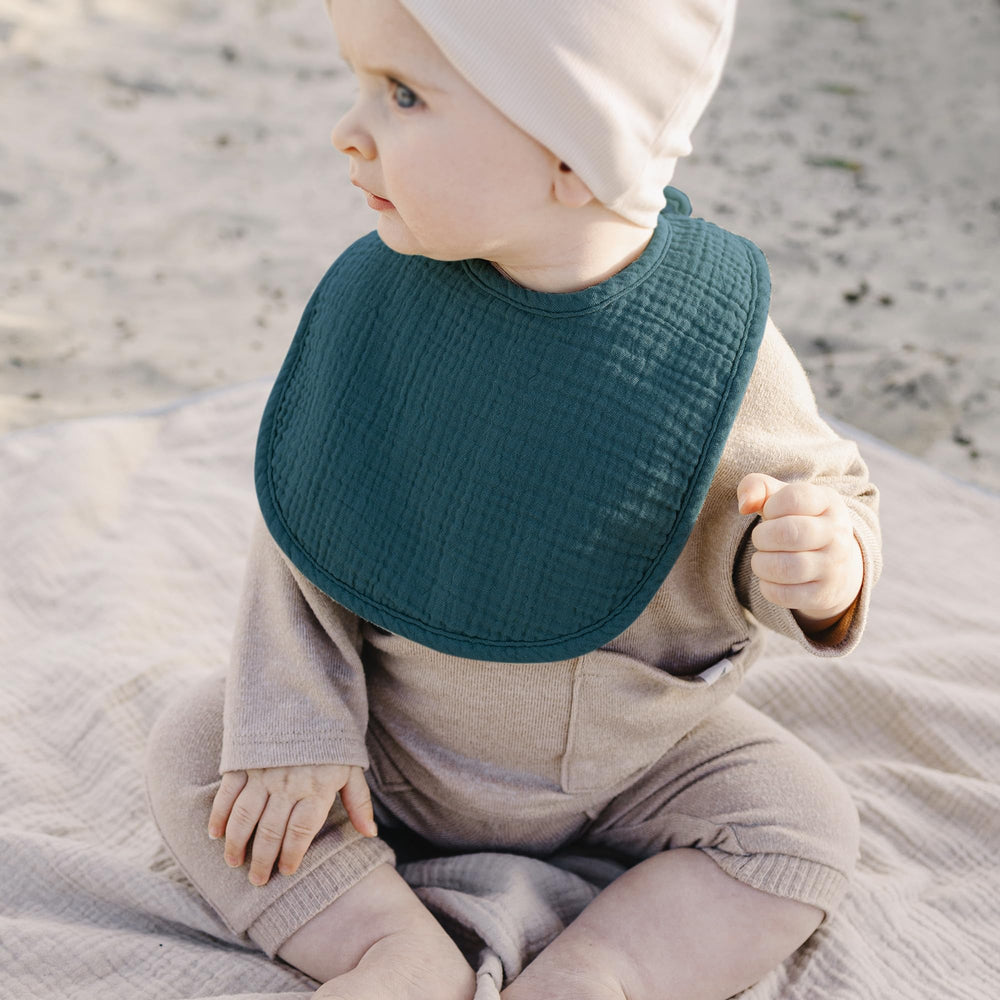 Konssy bib in use as burp cloth during feeding for versatility.