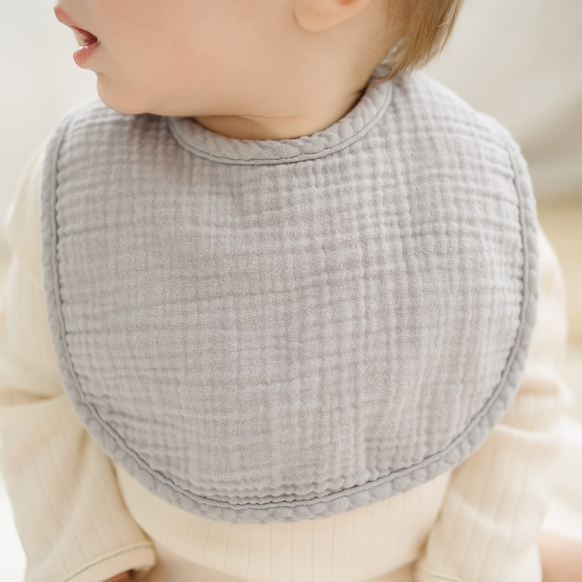 Konssy bib features adjustable snaps for a growing baby’s neck.