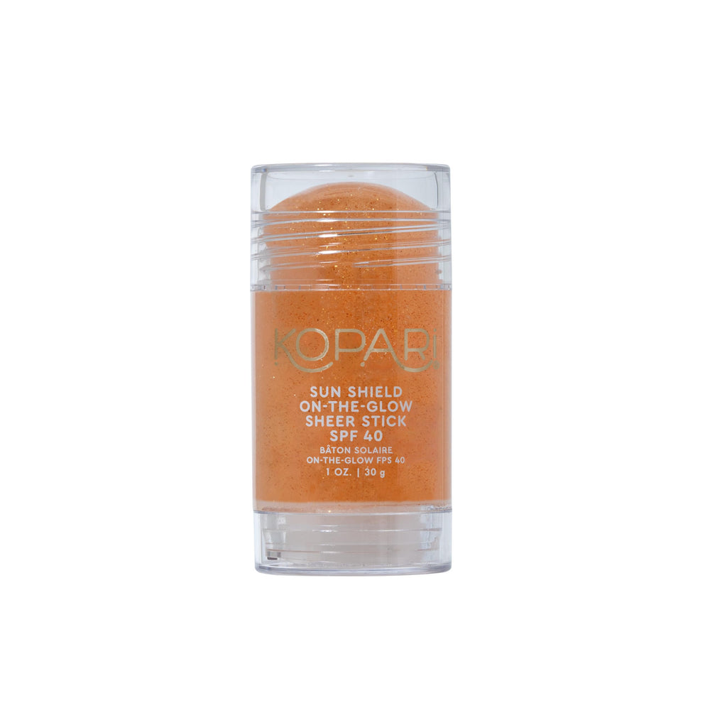 Kopari Sun Shield On-The-Glow stick applied to face for quick SPF protection