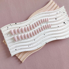 KQueenest dusty pink press-on nails on hand show short almond style for daily tasks.