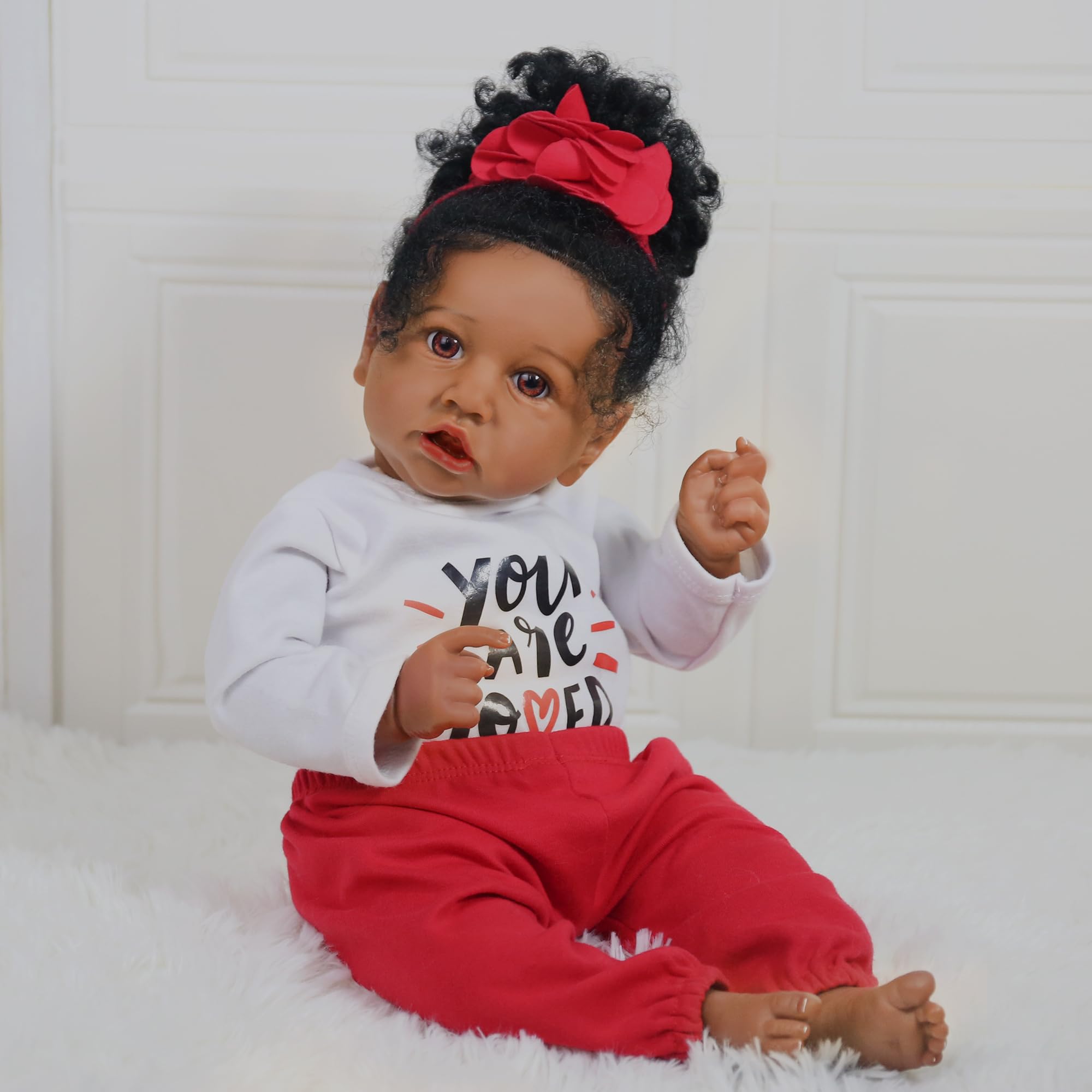 KSBD Realistic 20-inch doll posed sitting for easy display.