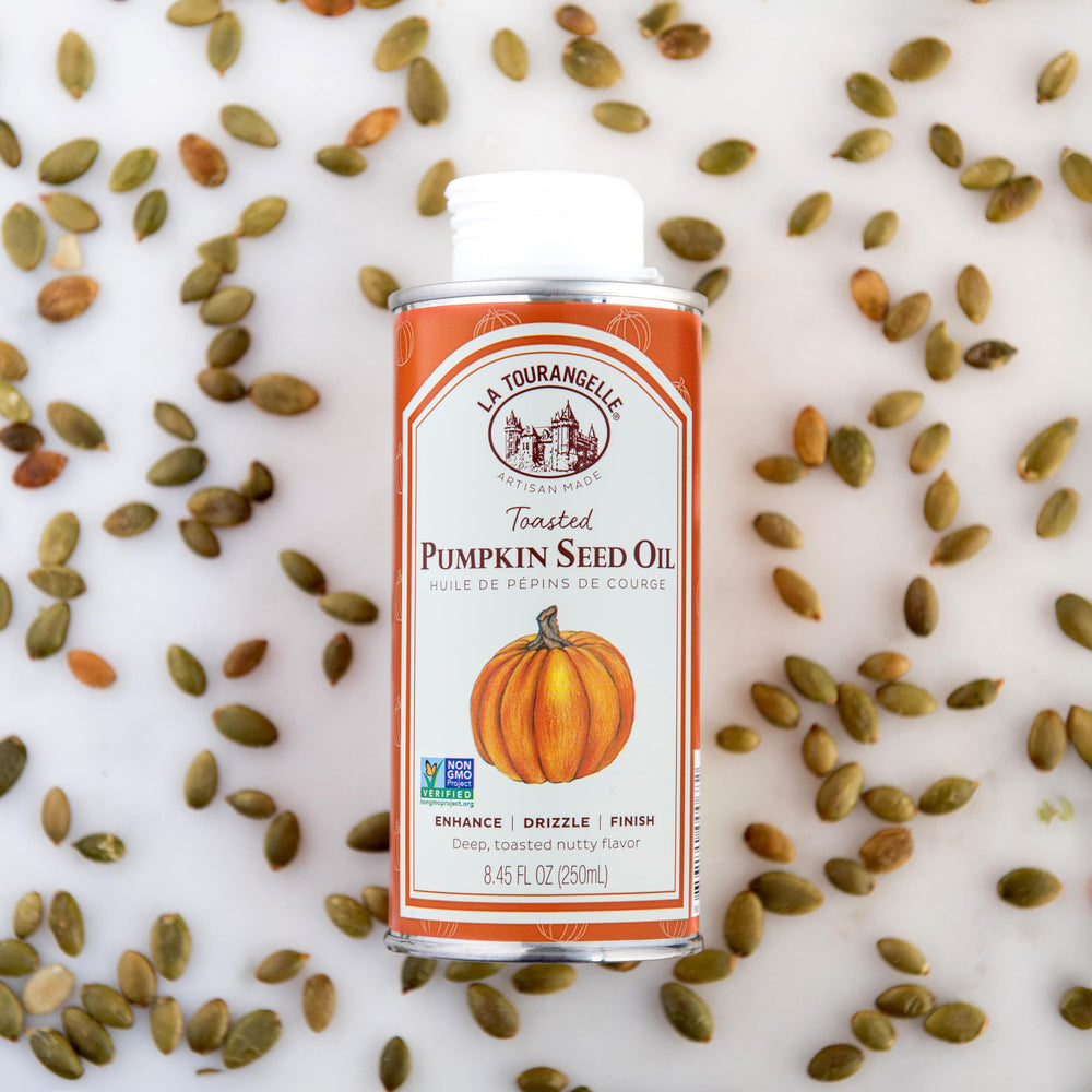 La Tourangelle Toasted Pumpkin Seed Oil on a busy kitchen counter with ingredients