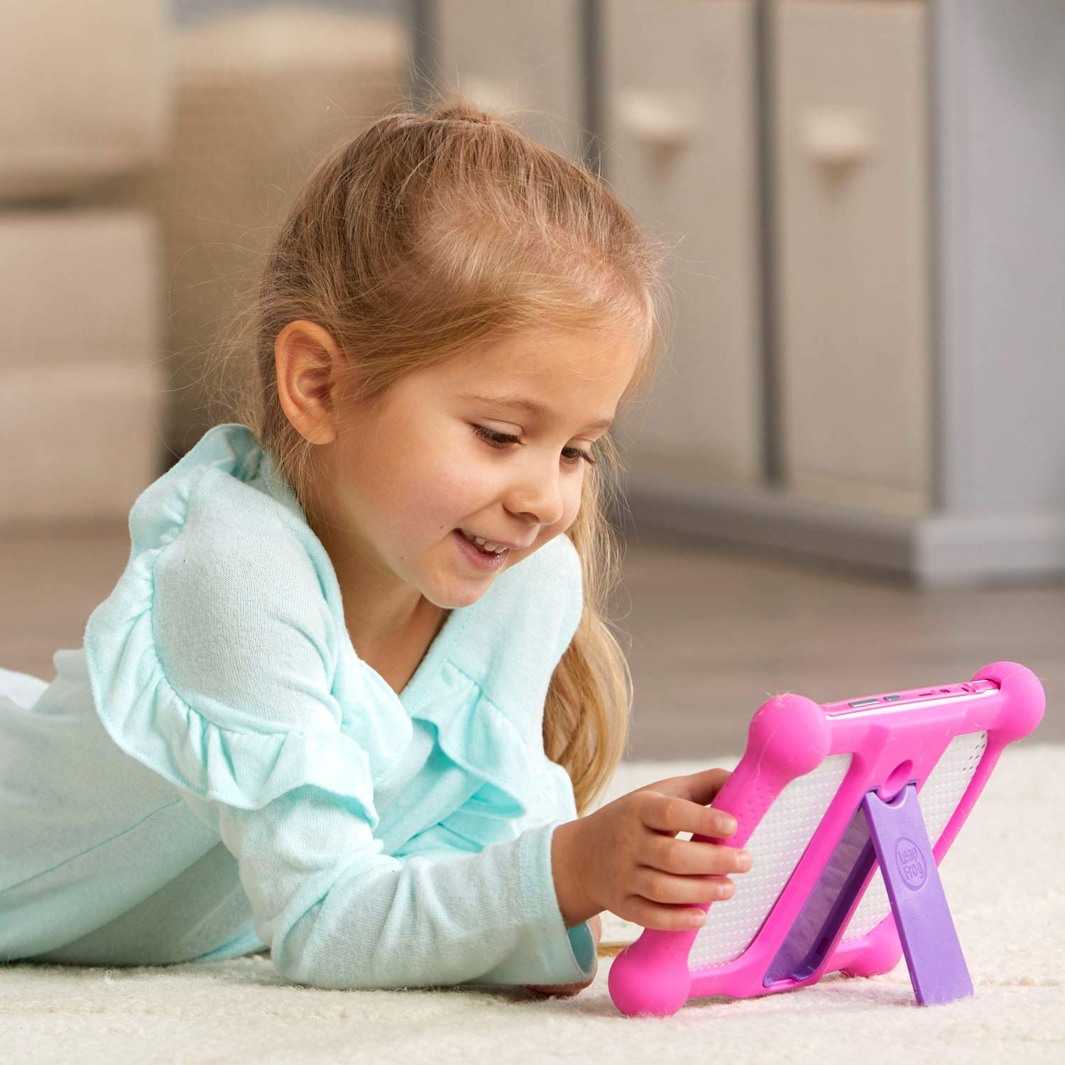 Child using LeapPad Academy pink tablet for learning activities