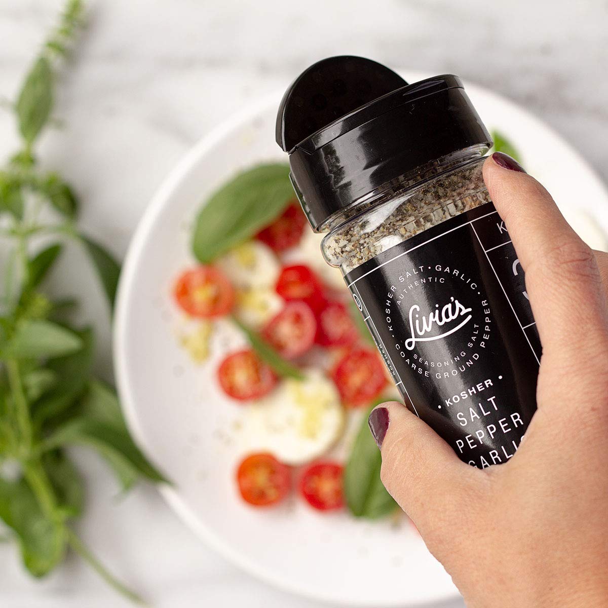 Livia’s Seasoning dispensed on chicken enhances savory aroma and moisture.