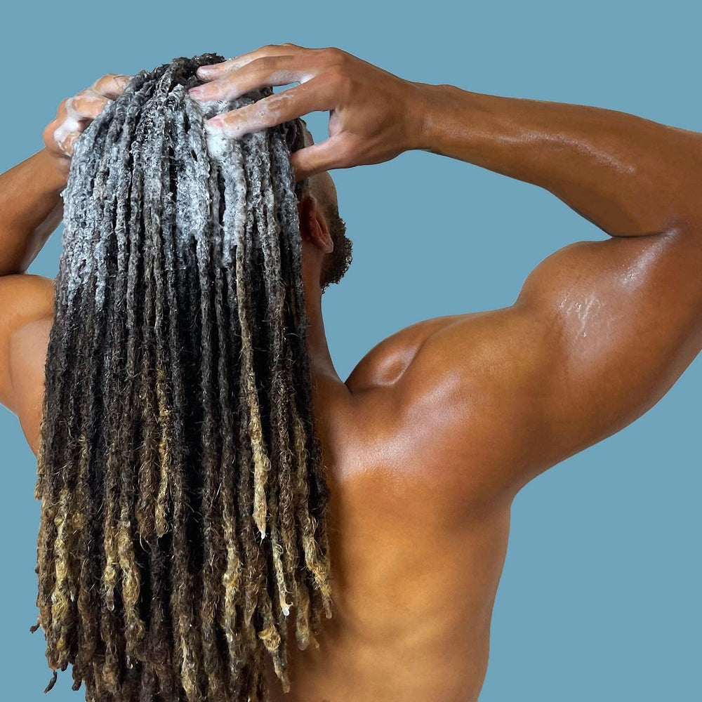 LOCssentials tea tree peppermint swirl label hinting at a cooling scalp experience.