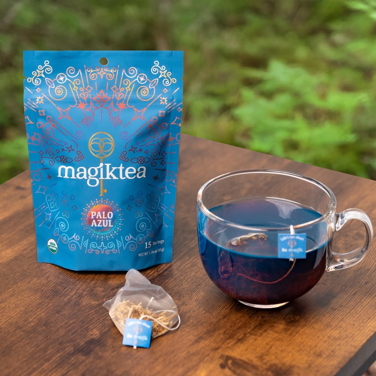 Magiktea Palo Azul brew in a glass cup shows blue glow in sunlight