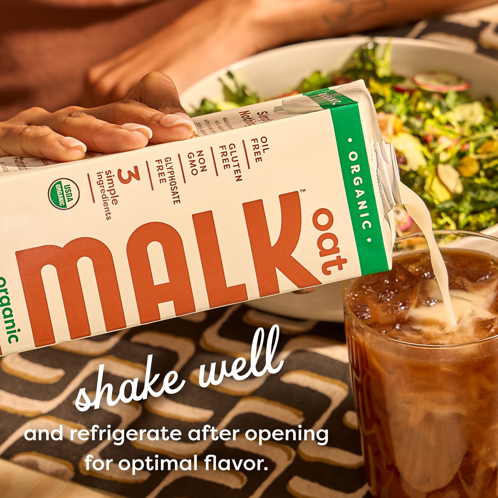 MALK Oat Milk Original being poured into a glass for a creamy dairy-free drink