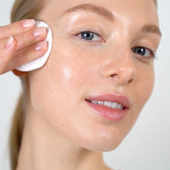 Cotton pad applying Mario Badescu Witch Hazel & Rosewater Toner to skin