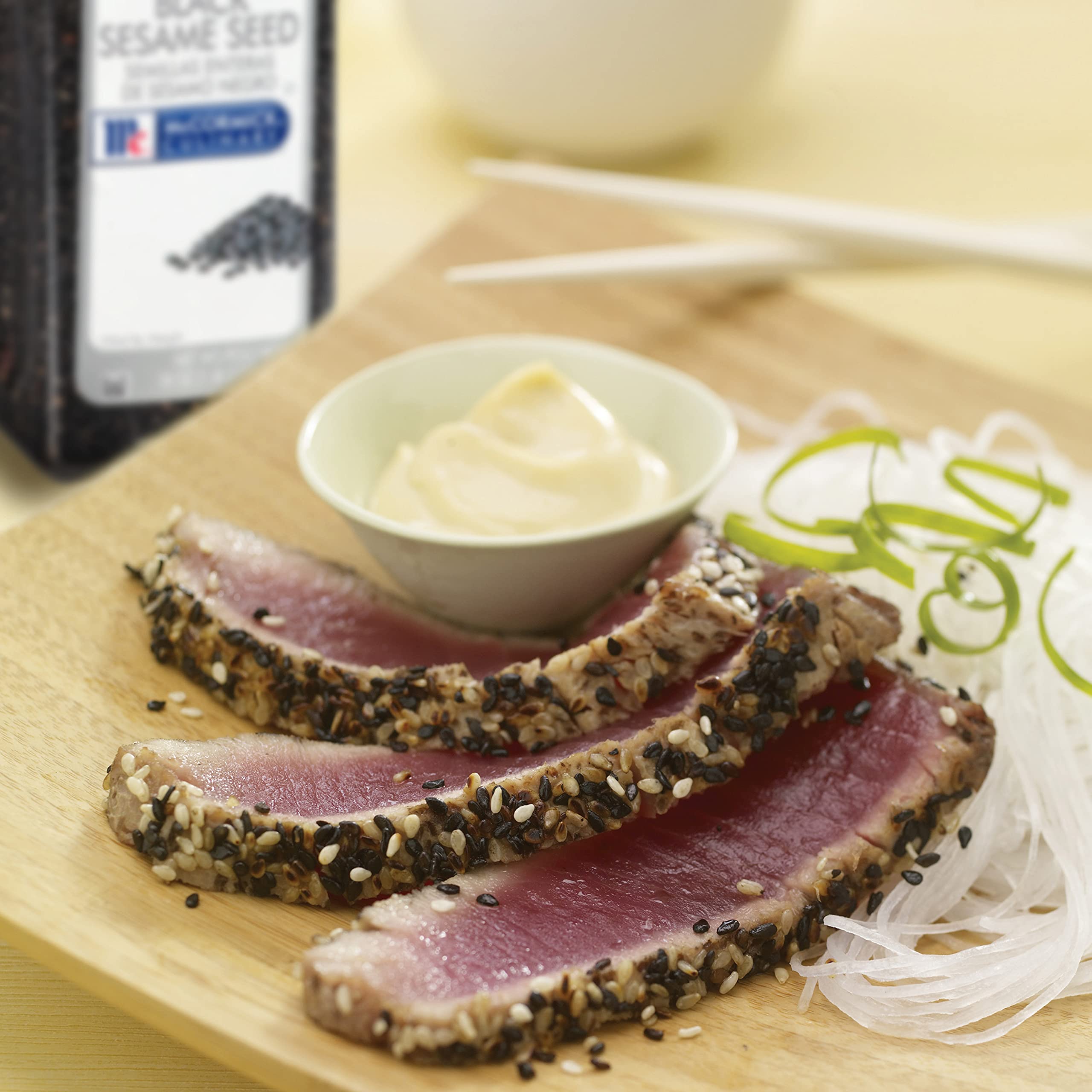 Garnishing sushi rolls with McCormick Culinary black sesame seeds for contrast
