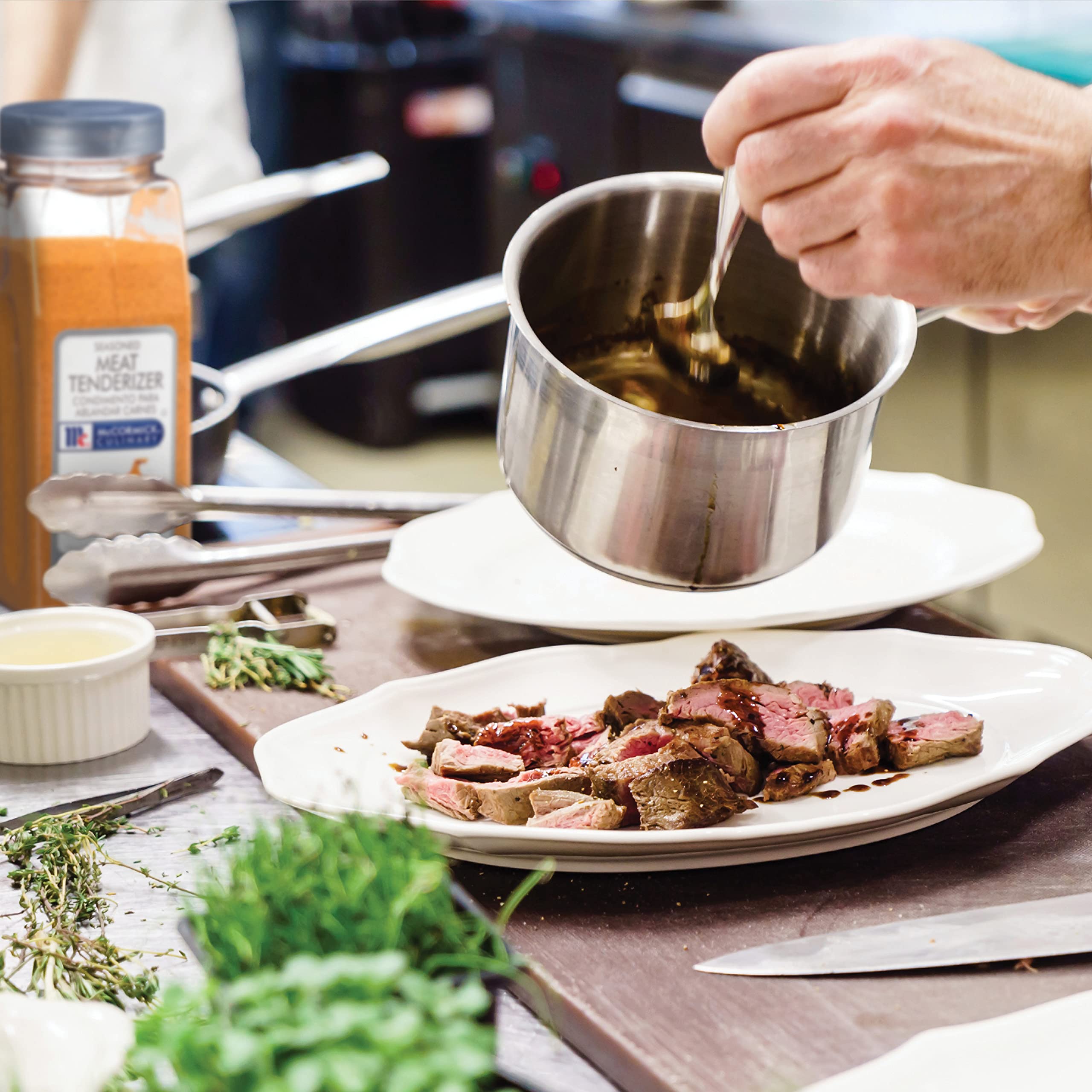 Applying McCormick Culinary tenderizer to meat before cooking.