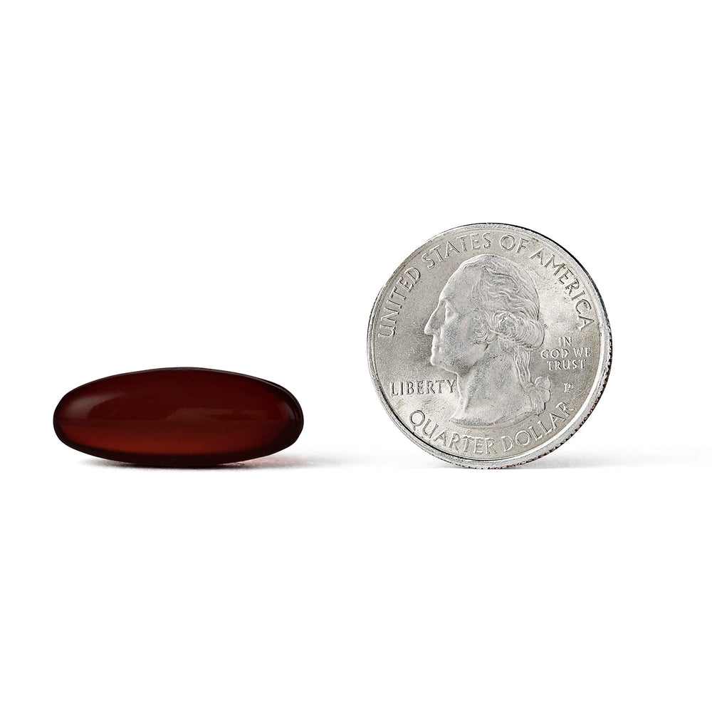 Person taking MegaRed softgel at breakfast, illustrating easy daily use.