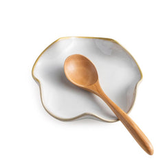 Miamolo spoon rest on stove top with ruffled beige edge, catches drips.