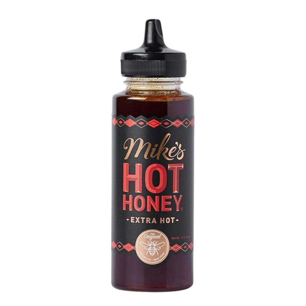 Mike's Hot Honey Extra Hot bottle on a wooden board adds spicy sweetness to dishes.