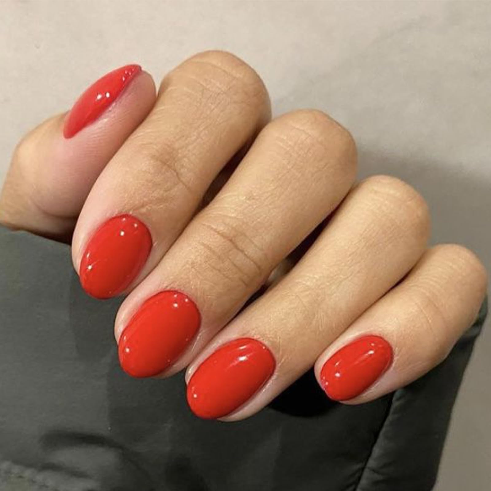 Modelones red short press-on nails oval packaging, ready-to-wear kit for quick manicures.