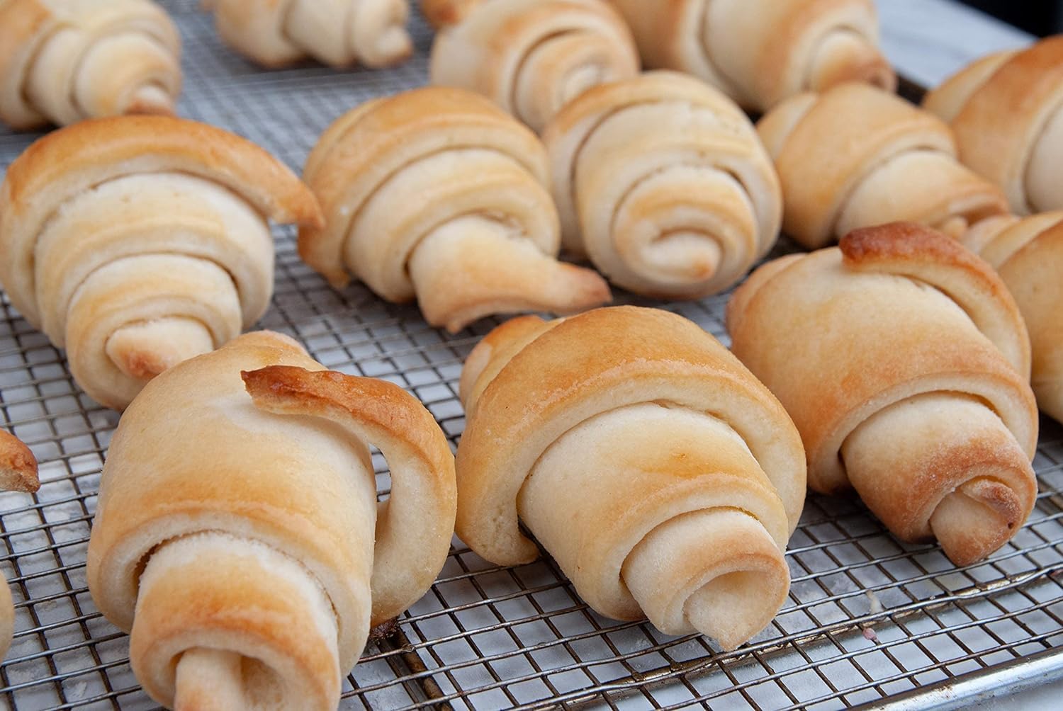 Baked crescent rolls on a tray, warm and fluffy from Mom's Place mix